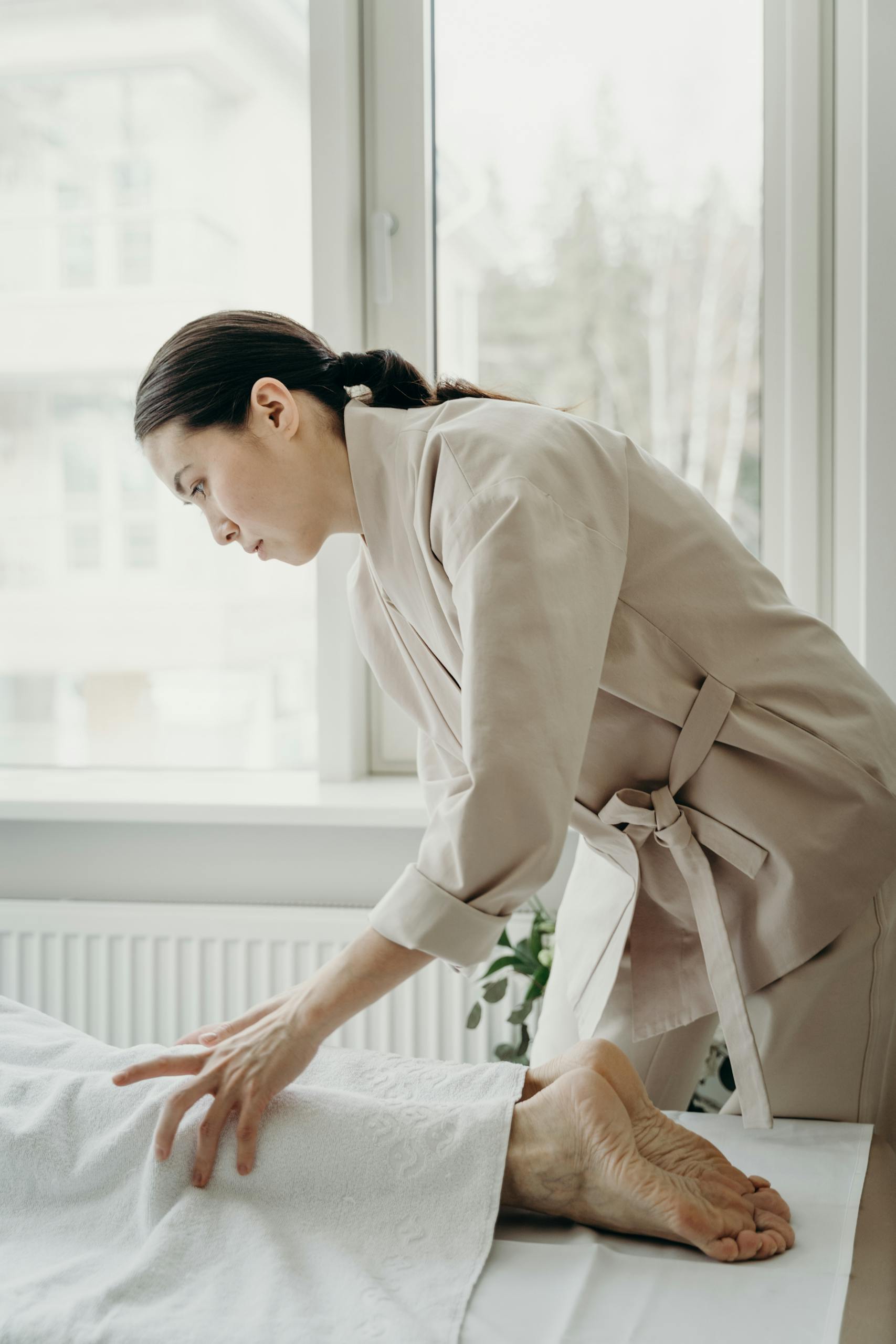 A skilled therapist administers a soothing leg massage in a bright spa room.